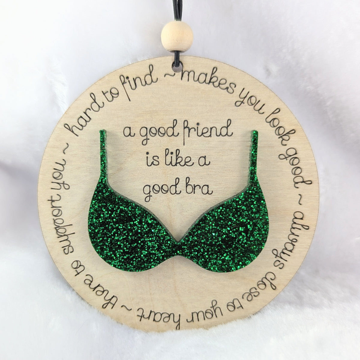 Friendship ornament with a green bra. Reads: A good friend is like a good bra. 